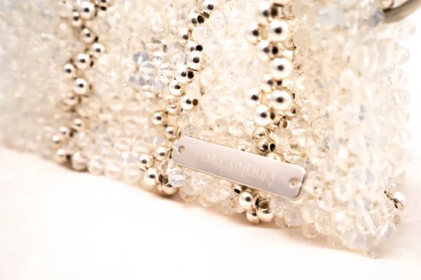 BOLSA PEQUEÑA DE CRISTALES BLANCO TRANSPARENTE Y BLANCO LECHOSO, FRANJAS EN ZIGZAG PLATEADAS