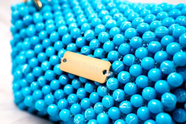 BOLSA MEDIANA CON CRISTALES ESTILO PERLA COLOR TURQUEZA CON LINEAS BLANCAS EN ALGUNOS CRISTALES