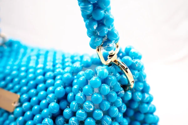 BOLSA MEDIANA CON CRISTALES ESTILO PERLA COLOR TURQUEZA CON LINEAS BLANCAS EN ALGUNOS CRISTALES